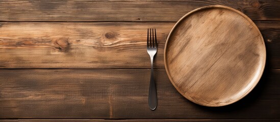 Poster - Empty plate with silver fork and knife on wooden background. copy space available