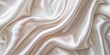 © kiimoshi - Close-up of rippled silk fabric with soft folds.