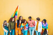 © Davide Angelini - Diverse group of young people celebrating gay pride festival day - Lgbt community concept with guys and girls hugging together outdoors - Multiracial trendy friends standing on a yellow background