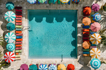 Aufkleber - Aerial perspective showcasing a pool surrounded by vibrant, colorful umbrellas providing shade for swimmers and sunbathers