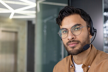 smiling customer service representative with headset in a modern office