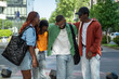 © DimaBerlin - Cheerful contented african american four friends girls and guys laughing urban walking together. Joyful happy group of black students have fun outdoor, chatting, sharing stories, enjoy stroll together