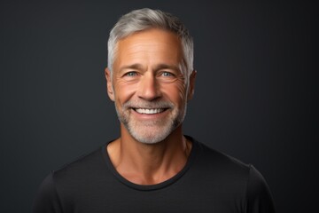 Canvas Print - Portrait of a smiling man in his 50s smiling at the camera on soft gray background