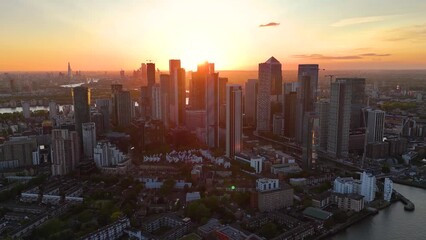 Wall Mural - Establishing aerial sunset view of the residential and office skyscrapers at Canary Wharf London, England, with the skyline of the City in the background