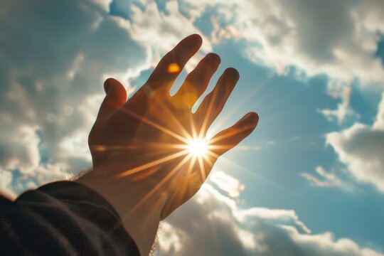 A Man Holding His Hand Up In The Sky With The Sun Shining Through His Fingers Praising and Praying