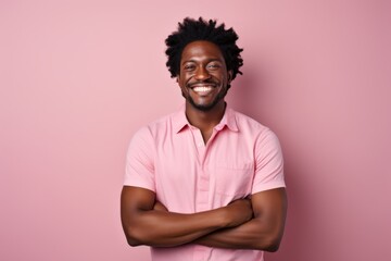 Canvas Print - Portrait of a smiling afro-american man in his 30s with arms crossed isolated on pastel or soft colors background