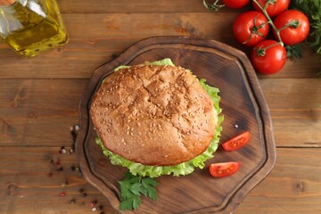 Poster - Delicious vegetarian burger served on wooden table, flat lay