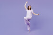 © ViDi Studio - Full body young woman wear pyjamas jam sleep eye mask rest relax at home hold pillow do winner gesture clench fists raise up leg dance isolated on plain purple background. Good mood night nap concept.