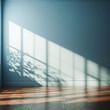 © Francesca Parità - sfondo blu polvere di interno con luce proveniente da una finestra su parete vuota con ombra di foglie e pavimento in legno marrone scuro con spazio vuoto per presentazione prodotto