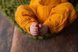 Fototapeta Do akwarium - The legs of a small child on a beige background