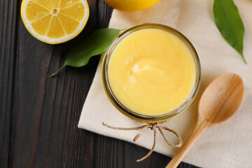 Poster - Delicious lemon curd in bowl, fresh citrus fruit and spoon on wooden table, top view