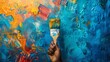 © Sasikharn - A raised fist holding a paintbrush dipped in vibrant colors, representing creative expression and freedom of speech