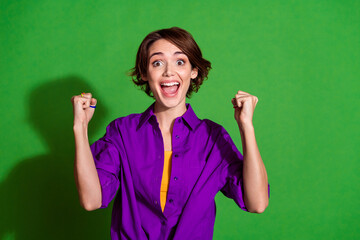 Sticker - Photo of funny young woman in purple stylish shirt and brown bob haircut celebrate her promotion at job isolated on green color background