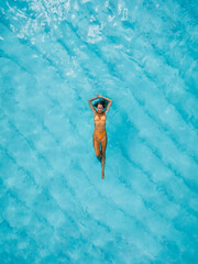 Canvas Print - Attractive woman relax and swimming in blue ocean. Drone view