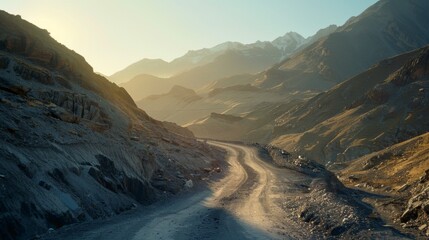 Poster - Sunrise illuminating a winding mountain road, casting long shadows across the rugged terrain.