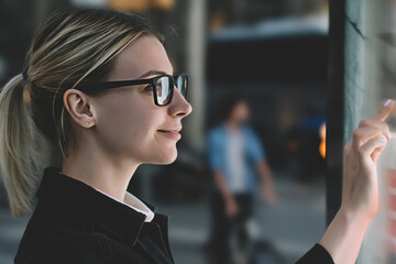 Wall Mural - smiling female standing at big display with advanced digital technology. young woman touching with f