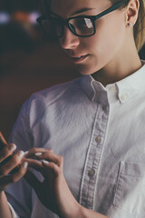 Wall Mural - female standing at big display with smartphone in hand. young woman reading information on mobile ph