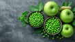 © Olga - A pair of bowls brimming with green beans rest beside green apples and fresh mint on a gray background