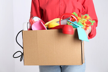 Wall Mural - Woman holding box of unwanted stuff on white background, closeup