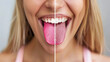 © Mehran - Woman showing her tongue before and after cleaning it. On one side, her tongue is covered with a white layer, and on the other side, it's pink and healthy.