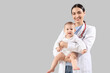 © Pixel-Shot - Female pediatrician with little baby on light background