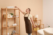 © Pixel-Shot - Young woman cleaning living room with pp-duster