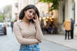 © Andrii Iemelianenko - Sad unhappy Indian young woman thinks over life concerns suffers from unfair situation outdoors. Problem feeling bad annoyed burnout grief. Hispanic girl alone on urban city street. Town lifestyles