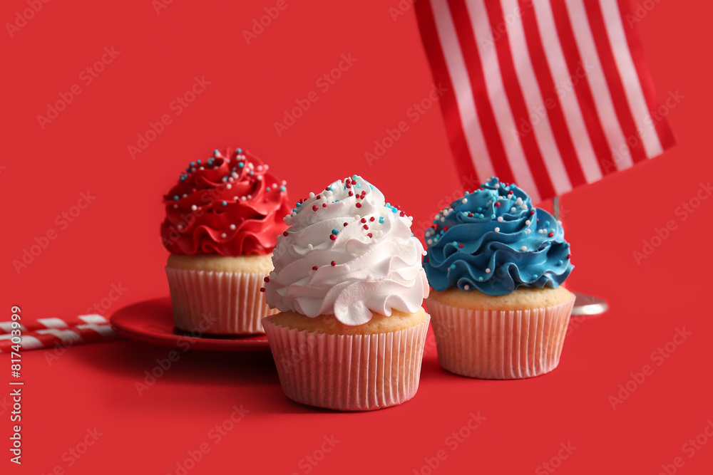 Tasty patriotic cupcakes with USA flag on red background. American Independence Day