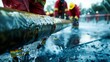 © Justlight - Precision and teamwork displayed as employees practice handling a large fire hose during a fire suppression drill at a refinery.