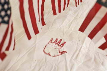 Wall Mural - memorial day banner with a child's handprint in a close-up view, framed by waving american flags in 