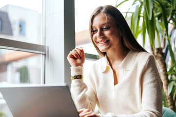 Poster - woman sitting at table using laptop computer