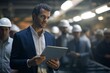 © alisaaa - confident businessman standing in the factory and holding digital tablet while working in boiler room control room of food processing plant