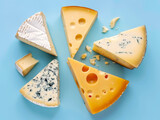 Fototapeta Do akwarium - Variety of cheese slices on blue background
