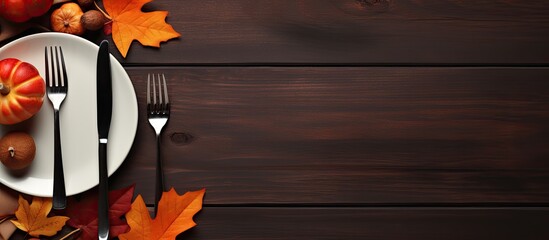 Poster - A festive autumn table with cutlery and vibrant fall leaves perfect for Thanksgiving Copy space image 86 characters