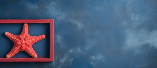 Leinwandbilder - Copy space image of a red starfish frame against a dark blue old background evoking the essence of a summer holiday concept
