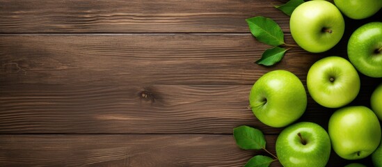 Poster - A captivating top down view of a wooden background featuring an arrangement of crisp green apples and ample free space for text