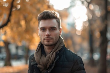 Poster - A man standing in a park with a scarf, suitable for outdoor fashion concepts