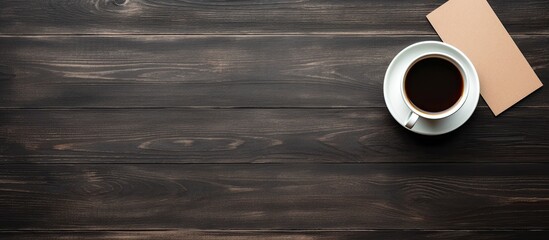 Poster - Flat lay with a black wooden background featuring blank paper sheets for brochures accompanied by a cup of coffee The image is a mock up. Creative banner. Copyspace image