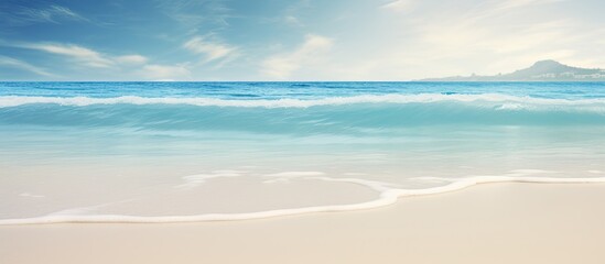 Wall Mural - A tropical beach with blurred waves and sand in the foreground Offers plenty of copy space for your image