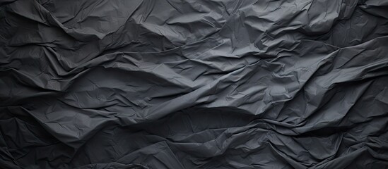 Wall Mural - A crumpled piece of dark grey paper creates a textured background perfect for showcasing a copy space image