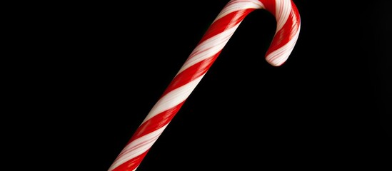 Aufkleber - Flat lay view of a Christmas candy cane isolated on a black background providing ample copy space in the image