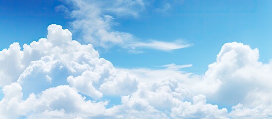 Poster - Copy space image featuring a serene blue sky adorned with fluffy white clouds