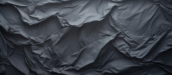 Poster - A crumpled piece of dark grey paper creates a textured background perfect for showcasing a copy space image