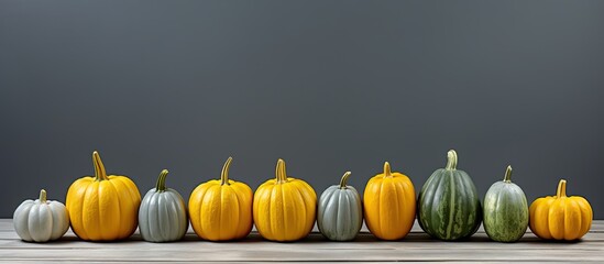 Poster - A copy space image of small yellow and green pumpkins arranged on a background of gray wooden planks