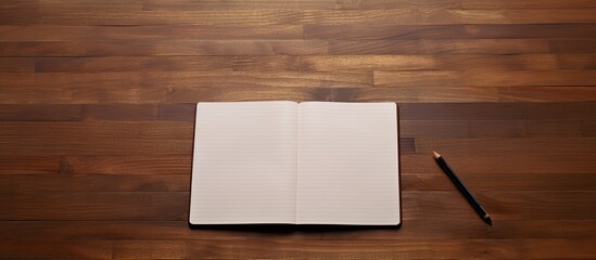 Fototapete - A wood table with a blank notebook providing ample copy space for writing or sketching