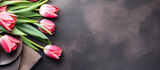 Flat lay of a festive Easter table setting adorned with gorgeous tulips and willow branches providing ample copy space for text