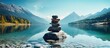 © HN Works - Mountain lake with a balanced stone pyramid surrounded by filtered blue water creating a serene and picturesque copy space image