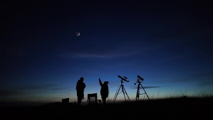 Wall Mural - amateur astronomers looking at the evening skies, observing planets, stars, moon and other celestial