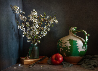 Wall Mural - Still life with flowering branches of fruit trees, a ripe apple and an old ceramic jug.