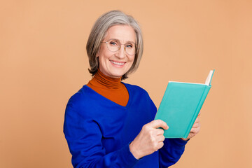 Sticker - Photo portrait of lovely pensioner lady hold read book dressed stylish blue garment isolated on beige color background